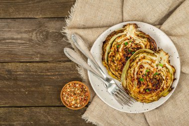 Bitki ve baharatlı ev yapımı vejetaryen biftekleri. Sağlıklı yiyecekler servis tabağında yemeye hazır, çatal bıçak takımı. Eski ahşap zemin, üst manzara