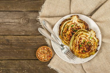 Bitki ve baharatlı ev yapımı vejetaryen biftekleri. Sağlıklı yiyecekler servis tabağında yemeye hazır, çatal bıçak takımı. Eski ahşap zemin, üst manzara