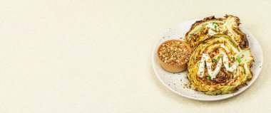 Ev yapımı vejetaryen lahana bifteği, baharat ve sos. Sağlıklı yiyecekler servis tabağında yemeye hazır. Taş beton arkaplan, pankart biçimi