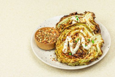 Ev yapımı vejetaryen lahana bifteği, baharat ve sos. Sağlıklı yiyecekler servis tabağında yemeye hazır. Taş beton arka plan, kapat