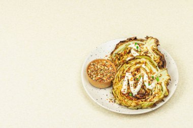 Ev yapımı vejetaryen lahana bifteği, baharat ve sos. Sağlıklı yiyecekler servis tabağında yemeye hazır. Taş beton arkaplan, kopyalama alanı