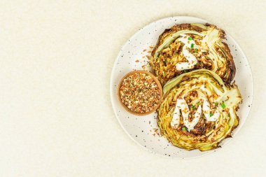 Ev yapımı vejetaryen lahana bifteği, baharat ve sos. Sağlıklı yiyecekler servis tabağında yemeye hazır. Taş beton zemin, üst görünüm