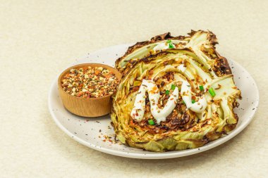 Ev yapımı vejetaryen lahana bifteği, baharat ve sos. Sağlıklı yiyecekler servis tabağında yemeye hazır. Taş beton arka plan, kapat