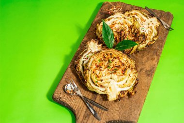 Bitki ve baharatlı ev yapımı vejetaryen biftekleri. Tahta kesme tahtasının üzerinde sağlıklı yiyecekler yemeye hazır. Modern sert ışık, koyu gölge, parlak yeşil arkaplan, kopyalama alanı