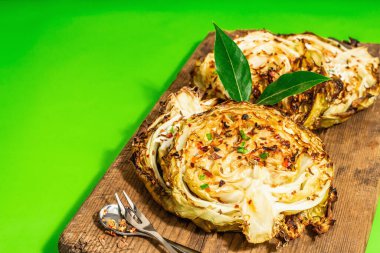 Bitki ve baharatlı ev yapımı vejetaryen biftekleri. Tahta kesme tahtasının üzerinde sağlıklı yiyecekler yemeye hazır. Modern sert ışık, koyu gölge, parlak yeşil arkaplan, kopyalama alanı