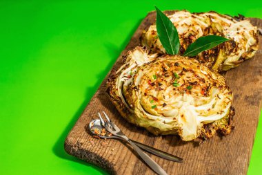 Bitki ve baharatlı ev yapımı vejetaryen biftekleri. Tahta kesme tahtasının üzerinde sağlıklı yiyecekler yemeye hazır. Modern sert ışık, koyu gölge, parlak yeşil arkaplan, kopyalama alanı