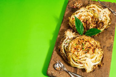 Bitki ve baharatlı ev yapımı vejetaryen biftekleri. Tahta kesme tahtasının üzerinde sağlıklı yiyecekler yemeye hazır. Modern sert ışık, koyu gölge, parlak yeşil arkaplan, kopyalama alanı