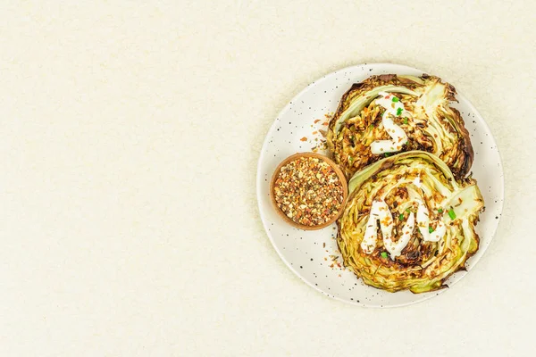 Ev yapımı vejetaryen lahana bifteği, baharat ve sos. Sağlıklı yiyecekler servis tabağında yemeye hazır. Taş beton zemin, üst görünüm