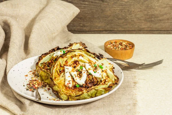 Ev yapımı vejetaryen lahana bifteği, baharat ve sos. Sağlıklı yiyecekler servis tabağında yemeye hazır, çatal bıçak takımı. Taş beton arka plan, kapat