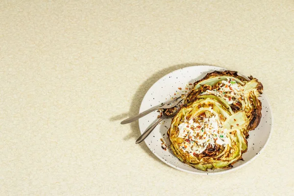 Ev yapımı vejetaryen lahana bifteği, baharat ve sos. Sağlıklı yiyecekler servis tabağında yemeye hazır, çatal bıçak takımı. Taş beton arkaplan, kopyalama alanı