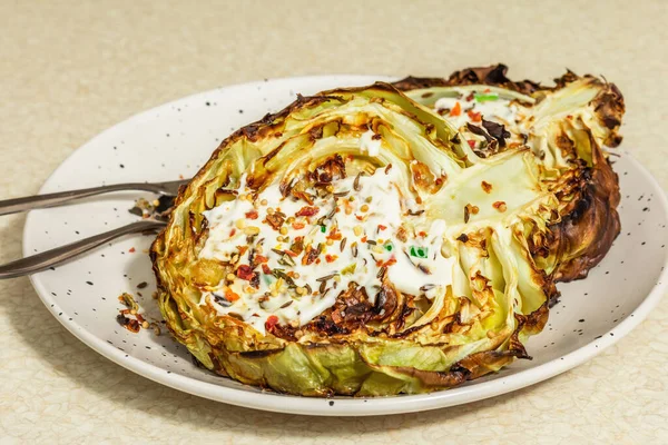 Ev yapımı vejetaryen lahana bifteği, baharat ve sos. Sağlıklı yiyecekler servis tabağında yemeye hazır, çatal bıçak takımı. Taş beton arka plan, kapat