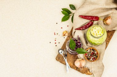 Mayalanmış lahana karışımı. Sağlıklı probiyotik yiyecekler, yemeye hazır. Geleneksel mutfak, baharatlar ve otlar. Vintage kesme tahtası, taş beton zemin, üst görünüm