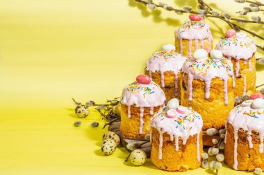 Geleneksel Paskalya pastası. Şekerleme ve dekorlu şenlikli tatlı yiyecekler. Yumurta, yuva, söğüt, modaya uygun sert ışık, karanlık gölge. Parlak sarı arkaplanda geleneksel pişirme, alanı kopyala