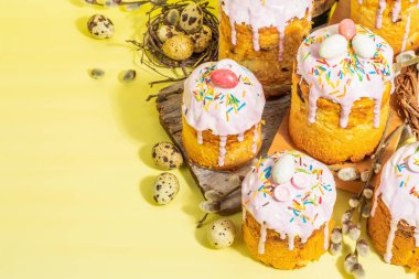 Geleneksel Paskalya pastası. Şekerleme ve dekorlu şenlikli tatlı yiyecekler. Yumurta, yuva, söğüt, modaya uygun sert ışık, karanlık gölge. Parlak sarı arkaplanda geleneksel pişirme, alanı kopyala