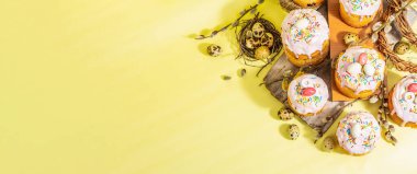 Geleneksel Paskalya pastası. Şekerleme ve dekorlu şenlikli tatlı yiyecekler. Yumurta, yuva, söğüt, modaya uygun sert ışık, karanlık gölge. Parlak sarı arkaplanda geleneksel pişirme, afiş biçimi