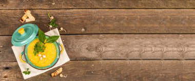 Eski ahşap arka planda bir kasede bezelye kremalı çorba. Kuru baklagiller, tost, kızarmış ekmekler ve yeşiller. Lezzetli vejetaryen sağlıklı yemek. Modaya uygun bir sert ışık, koyu gölge, kırsal stil, afiş biçimi