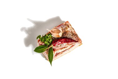 Kabuklu çiğ domuz eti, beyaz arka planda izole edilmiş periton eti. Taze maydanoz ve defne yaprağı, kırmızı biber, sarımsak ve baharatlar. Modaya uygun bir aydınlık, karanlık gölge, üst manzara.