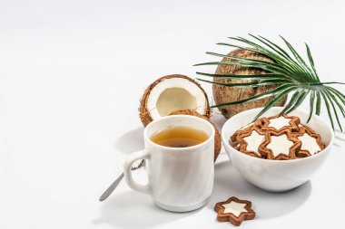 Glütensiz ve laktozsuz hindistan cevizli kurabiye. Ev yapımı sağlıklı hamur işleri, yeşil çay, güneşli bir sabah. Modaya uygun bir sabit ışık, koyu gölge, beyaz arkaplan, kopyalama alanı