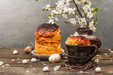 Köy tarzında geleneksel Paskalya pastası. Klasik fırın tenceresi, kirazlı erik dalları. Eski ahşap arka plan, tebrik kartı