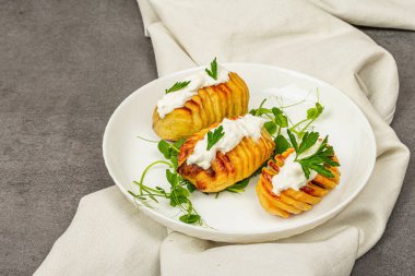 Taze bezelye filizli fırında akordeon patatesleri. Geleneksel Amerikan yemekleri, ev yapımı vegan diyeti. Taş beton zemin, düz yatış, kopyalama alanı