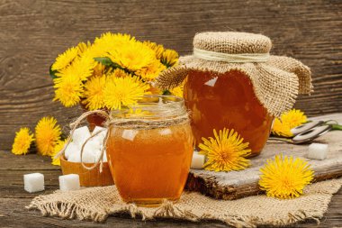 Karahindiba reçeli ya da cam kavanozda bir buket taze karahindiba çiçeğiyle bal. Mevsimlik ürün, köy tarzı, ahşap arka plan, yakın plan.