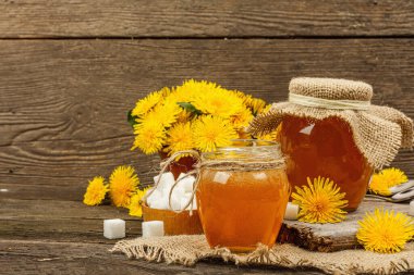 Karahindiba reçeli ya da cam kavanozda bir buket taze karahindiba çiçeğiyle bal. Mevsimlik ürün, köy tarzı, ahşap arkaplan, kopyalama alanı