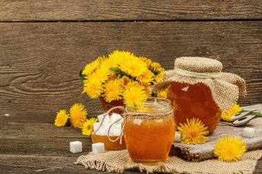 Karahindiba reçeli ya da cam kavanozda bir buket taze karahindiba çiçeğiyle bal. Mevsimlik ürün, köy tarzı, ahşap arkaplan, kopyalama alanı