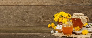 Karahindiba reçeli ya da cam kavanozda bir buket taze karahindiba çiçeğiyle bal. Mevsimlik ürün, köy tarzı, ahşap arkaplan, afiş biçimi