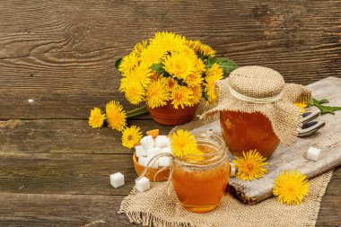 Karahindiba reçeli ya da cam kavanozda bir buket taze karahindiba çiçeğiyle bal. Mevsimlik ürün, köy tarzı, ahşap arkaplan, kopyalama alanı