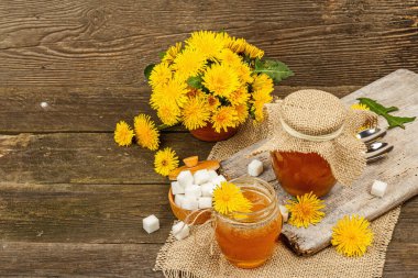 Karahindiba reçeli ya da cam kavanozda bir buket taze karahindiba çiçeğiyle bal. Mevsimlik ürün, köy tarzı, ahşap arkaplan, kopyalama alanı