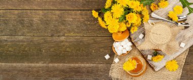 Karahindiba reçeli ya da cam kavanozda bir buket taze karahindiba çiçeğiyle bal. Mevsimlik ürün, köy tarzı, ahşap arkaplan, afiş biçimi