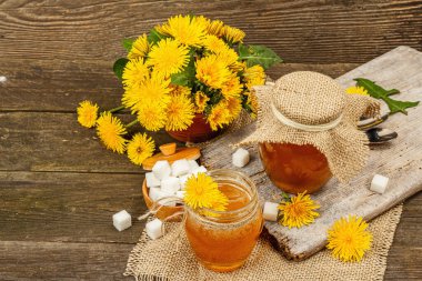 Karahindiba reçeli ya da cam kavanozda bir buket taze karahindiba çiçeğiyle bal. Mevsimlik ürün, köy tarzı, ahşap arkaplan, kopyalama alanı