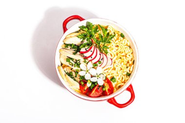 Tavuk, sebze ve otlu Asya erişteleri beyaz arka planda izole edilir. Geleneksel Japon çorbası, çorba ve kiraz çiçekleri, üst manzara.