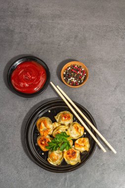 Domates soslu ve biberli kızarmış hamur köftesi. Moda vejetaryen yemekleri, modern sert ışık, karanlık gölge. Taş beton zemin, üst görünüm