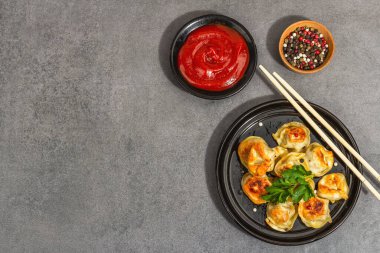 Domates soslu ve biberli kızarmış hamur köftesi. Moda vejetaryen yemekleri, modern sert ışık, karanlık gölge. Taş beton zemin, üst görünüm