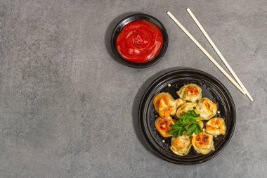 Domates soslu ve biberli kızarmış hamur köftesi. Moda vejetaryen yemekleri, modern sert ışık, karanlık gölge. Taş beton zemin, üst görünüm