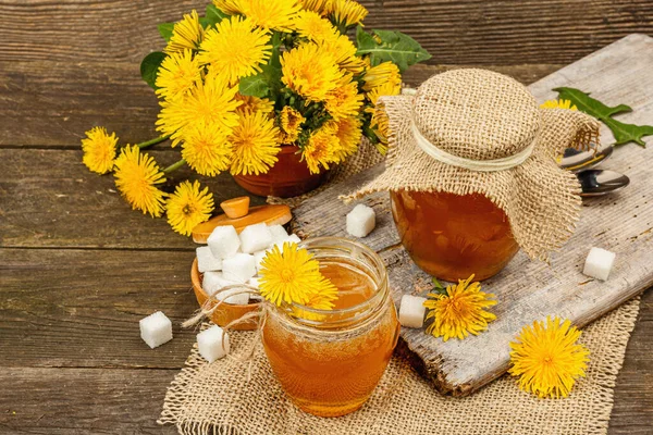 Karahindiba reçeli ya da cam kavanozda bir buket taze karahindiba çiçeğiyle bal. Mevsimlik ürün, köy tarzı, ahşap arka plan, yakın plan.