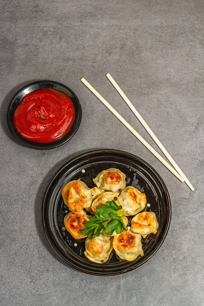 Domates soslu ve biberli kızarmış hamur köftesi. Moda vejetaryen yemekleri, modern sert ışık, karanlık gölge. Taş beton zemin, üst görünüm