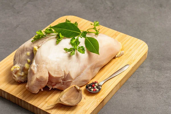 Raw chicken breast with spices and fresh parsley. Farm product, BIO poultry. Healthy food concept, trendy hard light, dark shadow. Grey concrete stone background, close up