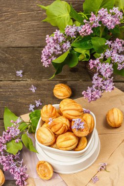 Yoğunlaştırılmış süt kremalı ceviz şeklinde kurabiyeler. Lezzetli kısa ekmekli sandviçler, kırsal tarzda modern vejetaryen pişirme. Eski tahta arkaplan, kopyalama alanı