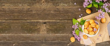 Yoğunlaştırılmış süt kremalı ceviz şeklinde kurabiyeler. Lezzetli kısa ekmekli sandviçler, kırsal tarzda modern vejetaryen pişirme. Eski ahşap arkaplan, pankart biçimi