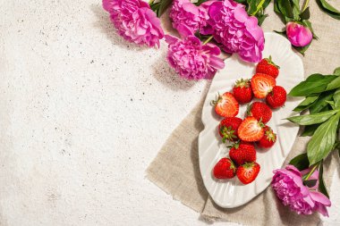 Tatlı olgun çilekler ve güzel kokulu şakayıklar. Yaz sıva arka plan, mevsimlik tasarım, sert ışık, koyu gölge, üst manzara