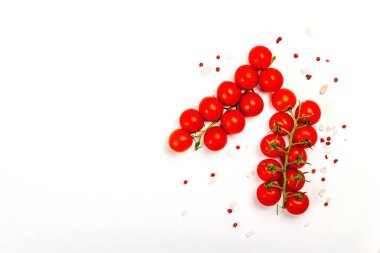 Domatesli kiraz, deniz tuzu ve beyaz arka planda izole edilmiş gül biberli arkaplan. Olgun sebze ve baharatlı bir aşçılık konsepti.