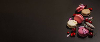 Şakayık çiçekli makarna ve siyah taştan bir arka planda olgun kirazlar. Tatlı tatlı, romantik stil, festival kartı, düz döşeme, sert ışık, koyu gölge, afiş biçimi