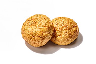 Beyaz arka planda susamlı taze çörekler. Hamburger pişirmek için vazgeçilmez bir malzeme. Sert bir ışık, karanlık bir gölge, yaklaş.