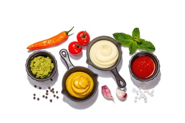Beyaz arka planda izole edilmiş soslar ve taze sebzeler. Ketçap, hardal, mayonez, wasabi. Baharatlar ve otlar, modaya uygun sert ışık, karanlık gölge, üst manzara