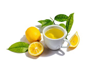 Olgun meyveli limon çayı ve beyaz arka planda taze yapraklar. Sıcak içecek seramik bardakta, sert ışık, koyu gölge, düz uzanma, yakın çekim