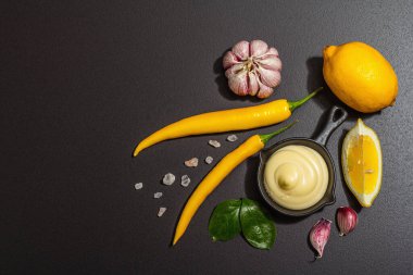 Yemek malzemeleri arka planında. Baharat, sebze, sarımsak, sarı biber. Siyah arkaplan, hazır yiyecek konsepti, düz konum, üst manzara