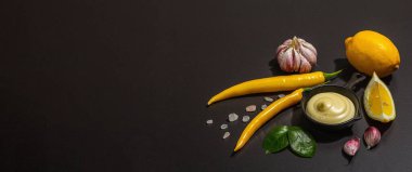 Yemek malzemeleri arka planında. Baharat, sebze, sarımsak, sarı biber. Siyah arkaplan, yemek hazırlama konsepti, düz konum, pankart biçimi