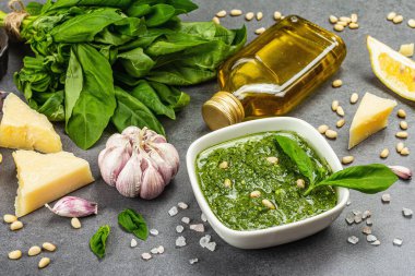 Çam fıstığı, parmesan ve sarımsaklı bir kasede pesto sosu. Geleneksel İtalyan yemekleri, gri taş beton zemin, pankart biçimi, kapat